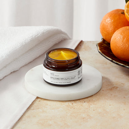 Miracle vitamin C mask travel size with towel and oranges in golden bowl in the background