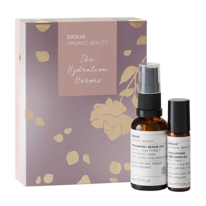 Hyaluronic Serum 200 hyaluronic acid serum in amber glass bottle sat next to hyaluronic eye complex hyaluronic acid eye serum in amber glass roll on bottle packaged in lilac and gold foiled box from Evolve Organic Beauty