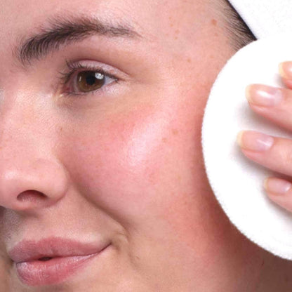 skincare model showing how to cleanse face with organic micellar cleansing water