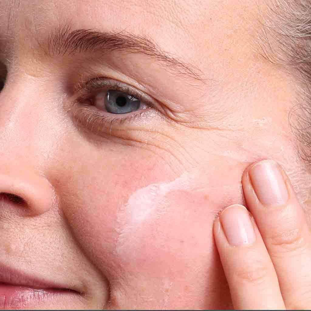 skincare model moisturising face with age defying face cream