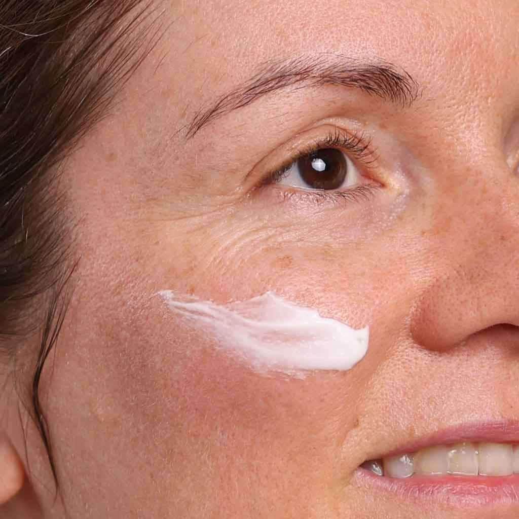 skincare model applying face moisturiser with daily renew organic peptide face cream