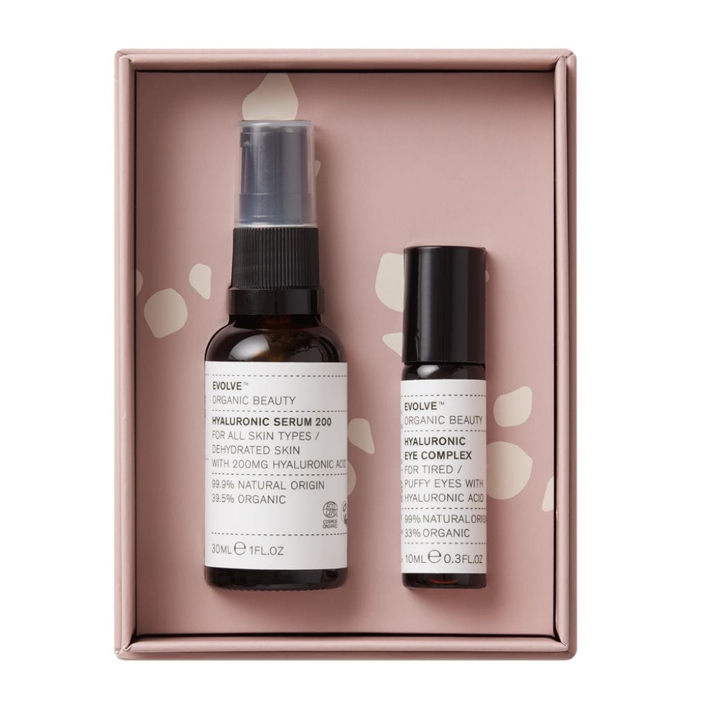 Hyaluronic Serum 200 hyaluronic acid serum in amber glass bottle sat next to hyaluronic eye complex hyaluronic acid eye serum in amber glass roll on bottle packaged in lilac box from Evolve Organic Beauty