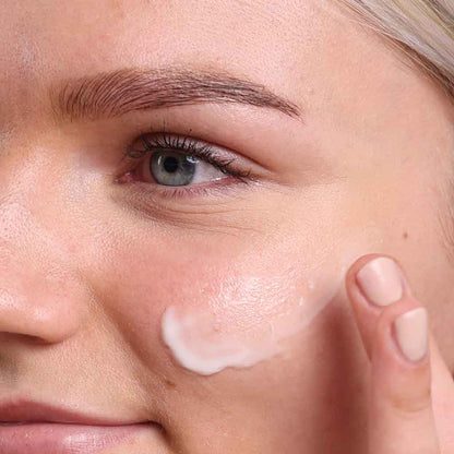 close up of face applying organic moisturiser